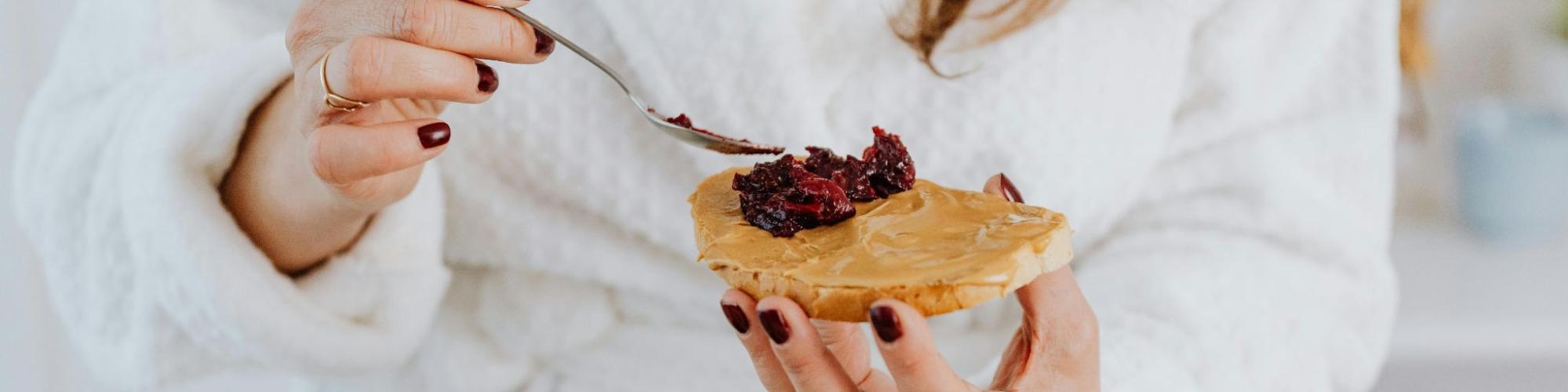 Spreading jelly onto peanut butter making a sandwich